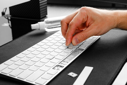 a man repairing a keyboard from a computer