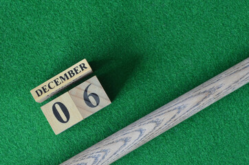 December 6, Number cube with a snooker stick on a green background, snooker table.