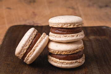 Coffee in glass cup and chocolate macarons on wooden background. Cozy autumn composition