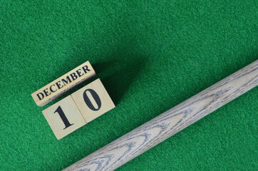 December 10, Number cube with a snooker stick on a green background, snooker table.