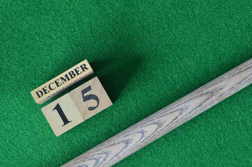 December 15, Number cube with a snooker stick on a green background, snooker table.