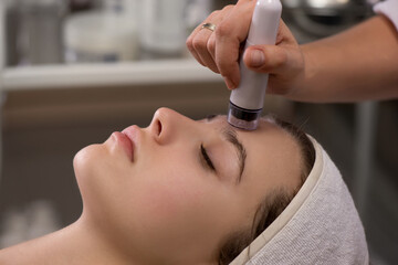 Rejuvenating facial treatment. Model getting lifting therapy massage in a beauty SPA salon.