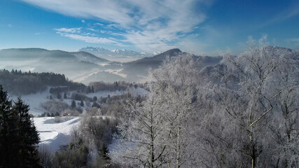 Aerial view of  white winter in the mountains and ski resort. Sunny winter day in alpine mountains. Winter holidays in Austria, Switzerland, Italy, Poland.