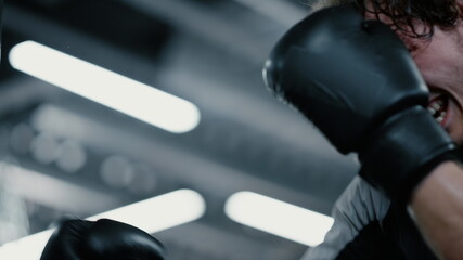 Eager kickboxer training blows at gym. Sportsman exercising in sport club © stockbusters