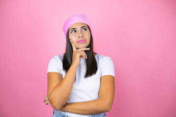 Obraz na płótnie Canvas Young beautiful woman wearing pink headscarf over isolated pink background thinking and looking to the side