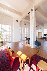 modern design of a huge white bright room with two red sofas and many large windows. full of sunshine. high ceiling and wooden parquet