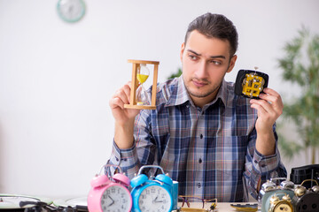 Young male watchmaker working in the workshop