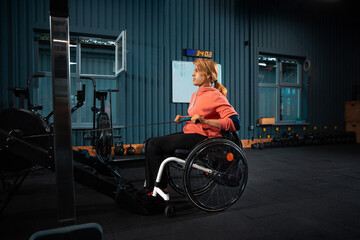 Weights. Disabled woman training in the gym of rehabilitation center, practicing. Active woman with handicap. Concept of healthy lifestyle, motivation, concentration, inclusion and diversity.