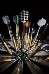 Lots of darts stuck randomly into the dartboard. One dart hit the center in the bull's eye