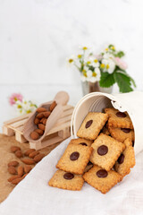 Cookies with almonds and chocolate with almond seeds on a light background. Beautiful homemade pastries. Selective soft focus.