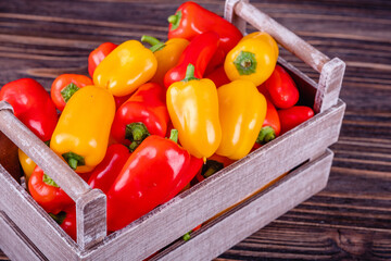 Fresh colored bell peppers on a rustic wooden background.