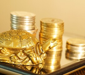 Metal turtle with coins on your smartphone.