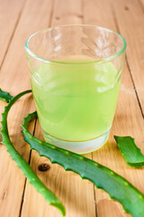 A glass of aloe juice. Aloe Vera leaves and juice