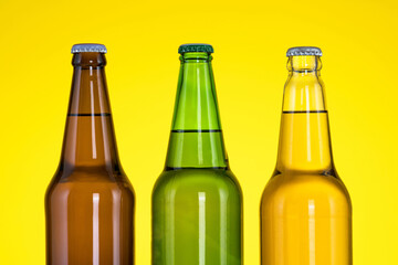 Group of Three bottles of beer isolated on yellow background