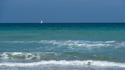 Un velero blanco navega por las aguas del Mediterraneo frente a Valencia