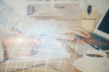 Multi exposure of world map hologram with man working on computer on background. Concept of worldwideweb.