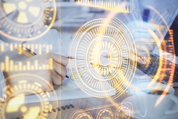 Fototapeta premium Technology theme hologram with man working on computer on background. High tech concept. Double exposure.