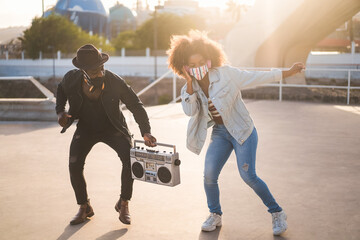 African friends dancing together while listening music with boombox - Focus on woman's face