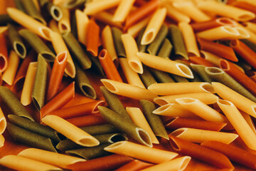 Frame made of colorful green, yellow and red penne pasta naturally coloured with tomato and spinach.