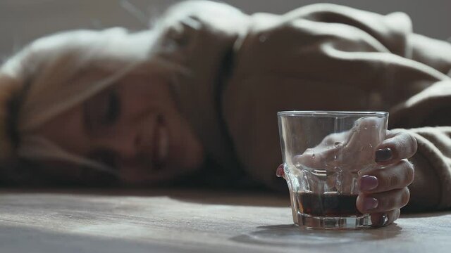Miserable woman in depression, drinking alcohol