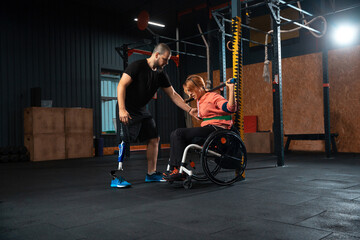 Fototapeta na wymiar Barbell. Disabled woman training in the gym of rehabilitation center, practicing. Active woman with handicap. Concept of healthy lifestyle, motivation, concentration, inclusion and diversity.
