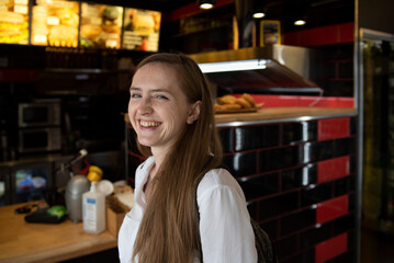 Girl laughs cheerfully on cafe background. Immediacy. Cheerful woman