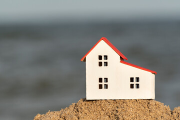 Fototapeta na wymiar Model house on the beach. Property on the seashore. Renting house sea views