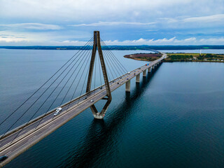 Large suspension highway bridge with cars and trucks passing. Farø bridge aerial view.