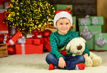 Fototapeta na wymiar Portrait kid with gift. toy shop open at xmas. merry christmas. happy new year. happy child santa hat. son ready to celebrate winter holidays. small boy excited with present. kid hold bear toy gift