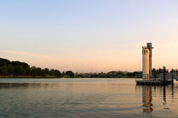 Obraz premium sunset over the river with a beautiful clear sky, a forest in the background and a couple of tall buildings - Guadalquivir in Seville, Spain