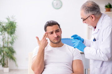 Young man visiting experienced doctor dermatologist