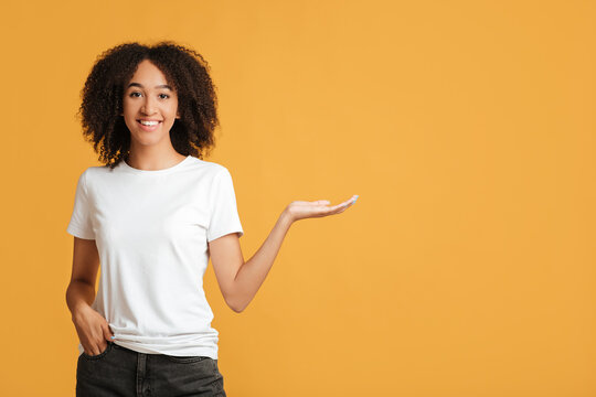 Best Offer, People Emotions And Lifestyle. Confident Smiling African American Lady Wearing In White T-shirt Points With Hand To Free Space