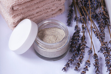 Fototapeta na wymiar Natural handmade scrub or facial mask with lavender, dry flowers and towels, top view. Spa and wellness concept