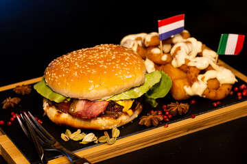 Hamburger and doughnuts and little flags.
Fast food on a chopper dish.