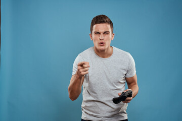 A man with a joystick in his hands entertainment leisure technology video games blue background white t-shirt