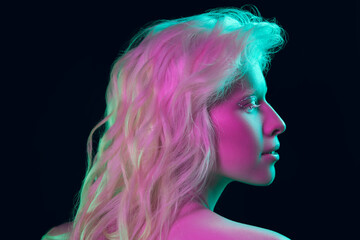 Fairytail. Close up portrait of beautiful albino girl on dark background in neon light. Blonde female model with dreamlike make-up and well-kept skin. Concept of beauty, cosmetics, style, fashion.