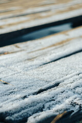Fototapeta premium Frozen icy old boards in the snow close up