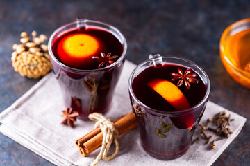 Mulled wine on a dark background. Two cups of autumn mulled wine on a linen napkin. Christmas hot drink