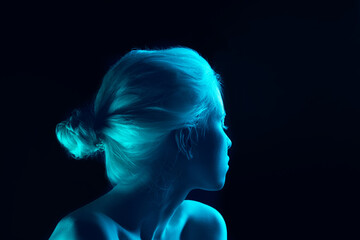 Blue. Close up portrait of beautiful albino girl on dark background in neon light. Blonde female model with dreamlike make-up and well-kept skin. Concept of beauty, cosmetics, style, fashion.