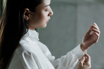 Woman rolling up her shirt sleeves.