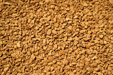 Background of coffee granules at life-size magnification.