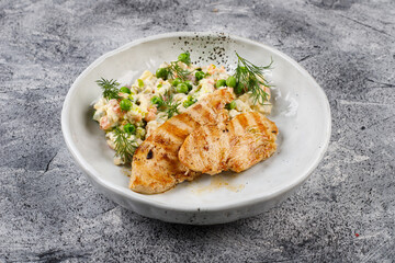 Healthy lunch - fried chicken breast and Olivier salad on a light plate background
