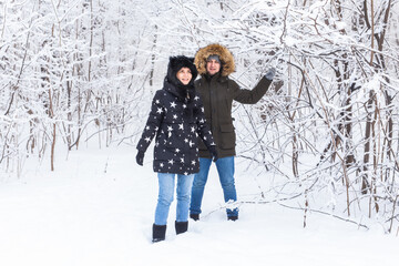 Young couple in love have fun in the snowy forest. Active winter holidays.