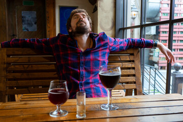 A drunk man sleeps in a bar. Alcohol, the fight against alcohol addiction, loneliness, crisis, dismissal. Unhealthy lifestyle concept.