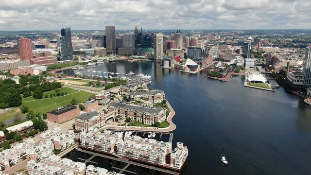 Gorgeous aerial establishing shot during summer day, Baltimore Inner Harbor in Maryland, USA, downtown financial district skyline, Patapsco River and Chesapeake Bay with boats, waterfront homes