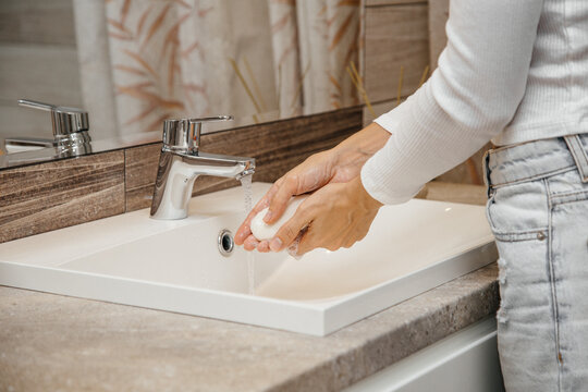 Human washes his hands with soap in the bathroom. Preventing the spread of viral infection, coronavirus (COVID-19). Clean hands are a guarantee of health