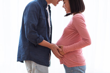 Happy Korean Husband Touching Pregnant Wife's Belly Standing At Home