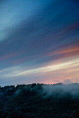 Fototapeta premium Abend Nebel über Landschaft mit bewaldetem Tal