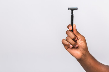 Close up photo of african american man's hand holding razor isolated over white background.