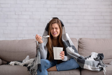 Heartbroken young woman eating ice cream from bucket while watching romantic movie on TV, feeling depressed and lonely - obrazy, fototapety, plakaty